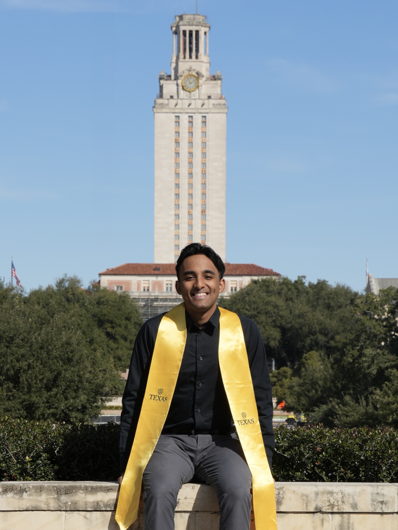 Om sitting on the University of Texas wall in front of the UT Tower